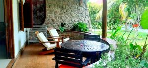 een patio met een tafel en stoelen voor een gebouw bij The Islander Hotel in Grand'Anse Praslin