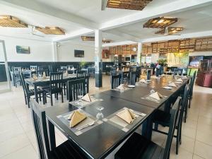 a dining room with a long table and chairs at Hotel Blackstone in Hambantota