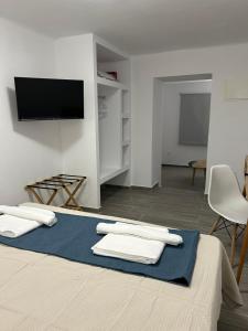 a bedroom with a bed with a tv on the wall at DK Square in Andros
