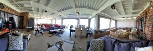 una gran sala de estar con sofás y una pared de ladrillo. en Bazley la Paradis, en Bazley Beach