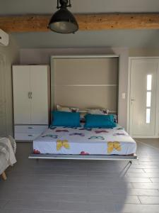 1 dormitorio con 1 cama grande con almohadas azules en La Belhomière - Sérénité, en Vins-sur-Caramy