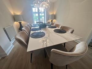 a dining room with a table and leather chairs at Cotswolds Retreat - Bath & Castle Combe - Hot Tub in Chippenham