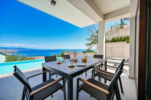 a dining table and chairs on the patio of a house at Villa Norma in Opatija