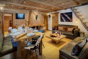 a living room with a table and a couch at Chalet Artedaz - OVO Network in La Clusaz