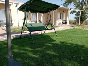 um balanço verde no quintal de uma casa em sylias village em Skála Korinoú