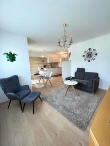ein Wohnzimmer mit 2 Stühlen, einem Sofa und einem Tisch in der Unterkunft Ferienwohnungen-Am Kurpark in Bad Saarow
