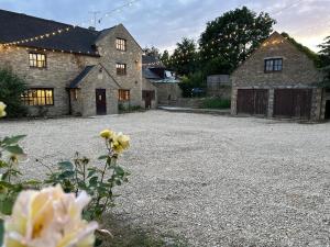 奇彭納姆的住宿－Cotswolds Retreat - Bath & Castle Combe - Hot Tub，石头房子前面的大碎石车道