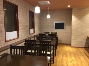HOTEL CARNA A - Vacation STAY 53725v في كوماموتو: غرفة طعام مع أرضيات خشبية وطاولات وكراسي