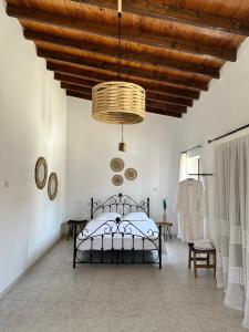 a bedroom with a bed and a wooden ceiling at Villa Saint George Stone Costa Demetriou in Kathikas