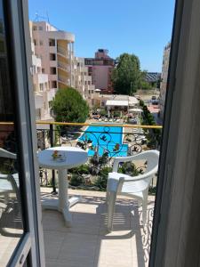 un balcone con tavolo e sedie e una piscina di Апартамент на солнечном берегу a Sunny Beach