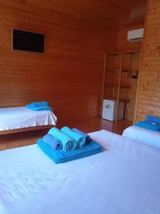 a room with two beds with blue towels on them at Abkhazsky Dvorik in Gagra