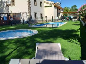 un patio trasero con piscina y parque infantil en Camping las Catalinas, en Riolobos