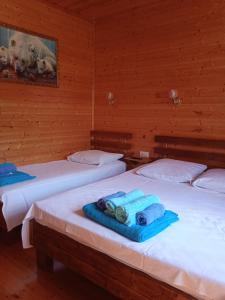 two beds with towels on them in a room at Abkhazsky Dvorik in Gagra