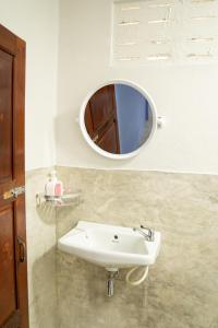 La salle de bains est pourvue d'un lavabo blanc et d'un miroir. dans l'établissement Butterfly Hostel, Pai, à Pai