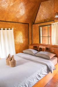 a bedroom with a bed with two shoes on it at Butterfly Hostel, Pai in Pai