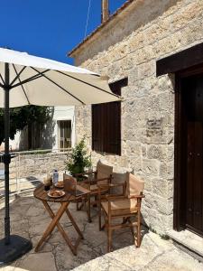a patio with a table and an umbrella at Villa Saint George - Stone Costa in Kathikas