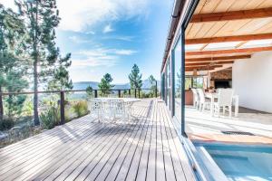 a wooden deck with a table and chairs on it at Avani Lodge Private Nature Reserve in Botrivier