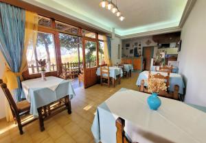 un ristorante con tavoli e sedie e una stanza con finestre di Lappa Hotel a Plakiás