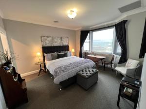 斯坦利Number 10 -King bed with breakfast的一间卧室，里面有一张床、一把椅子和一扇窗户。