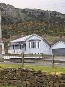 a house with a fence in front of a mountain at Number 10 -King bed with breakfast in Stanley