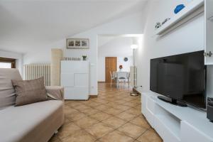 ein Wohnzimmer mit einem Flachbild-TV und einem Sofa in der Unterkunft Lago di Garda VC, dimora Charme of Butterfly in Cavaion Veronese