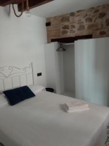 1 dormitorio con cama blanca y almohada azul en SEÑORÍO DE ORGAZ III, en Toledo