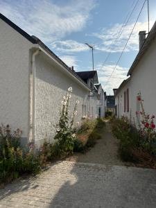 an alley with white buildings and flowers on the side at Villa en bord de mer in Pornichet