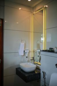 y baño con lavabo blanco y espejo. en Villa Sasha By Elixir Cliff, en Varkala
