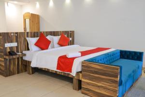 1 dormitorio con 1 cama grande con almohadas rojas y azules en Villa Sasha By Elixir Cliff, en Varkala