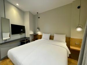 Schlafzimmer mit einem großen weißen Bett und einem Flachbild-TV in der Unterkunft Nevv Bosphorus Hotel & Suites in Istanbul