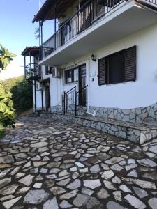 a house with a stone walkway in front of it at Gourgiana Apartments in Andritsaina