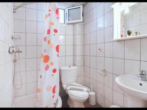 a bathroom with a toilet and a shower curtain with polka dots at Panagiotis Hotel in Skala Sotiros