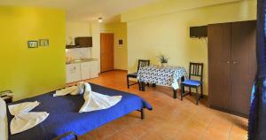 a room with two beds and a table and a kitchen at Panagiotis Hotel in Skala Sotiros