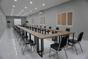 una lunga sala conferenze con un lungo tavolo e sedie di Hotel Luansa Klui a Mangsit