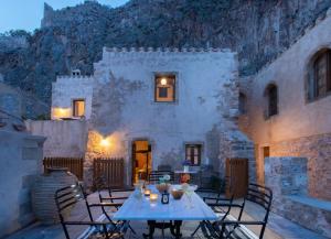 a patio with a table and chairs and a building at Bastione Malvasia Hotel (ex New Malvasia) in Monemvasia