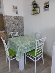 uma mesa e cadeiras com uma toalha de mesa verde e branca em Azalea em Prilepo