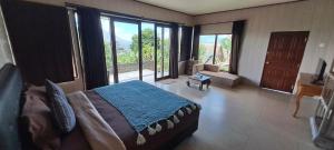a bedroom with a large bed and a large window at The Kayuan in Kintamani