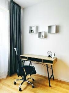 een bureau en een stoel in de kamer bij Good Vibes Apartment in Sighetu Marmaţiei