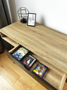 uma mesa de madeira com livros em cima em Good Vibes Apartment em Sighetu Marmaţiei