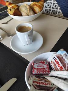 stół z filiżanką kawy i talerzem jedzenia w obiekcie Logis Hôtel Vannes Nord Le Clos Des Hortensias w mieście Locqueltas