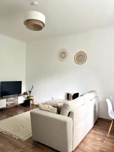 a white living room with a white couch and a tv at Beethoven Apartman in Budapest