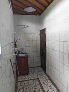 un bagno con lavandino, doccia e porta di Deux-Palmes-Kribi, proche de la plage, confortable et adapté aux familles a Kribi
