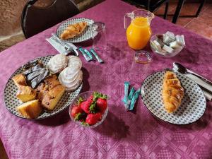 różowy stół z talerzami wypieków i truskawek w obiekcie CASERIO RECTORAL DESTERIZ w mieście Ourense