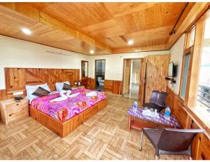 sypialnia z dużym łóżkiem i drewnianym sufitem w obiekcie Hotel Him Paradise, Manali w mieście Manāli