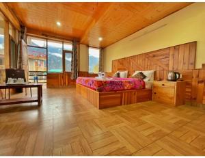 sypialnia z dużym łóżkiem i drewnianą podłogą w obiekcie Hotel Him Paradise, Manali w mieście Manāli
