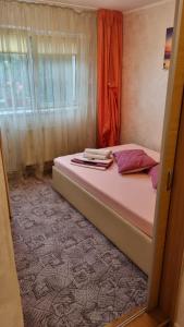 sypialnia z łóżkiem z różową pościelą i oknem w obiekcie Miruna w Konstancy