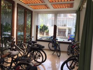 a group of bikes parked in a room with windows at Hotel Eden in Grado