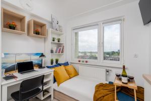 Habitación pequeña con escritorio y cama con almohadas amarillas. en Czarnowiejska Micro Studio, en Cracovia