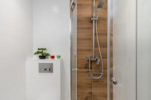 La salle de bains est pourvue d'une douche avec une porte en verre. dans l'établissement Czarnowiejska Micro Studio, à Cracovie