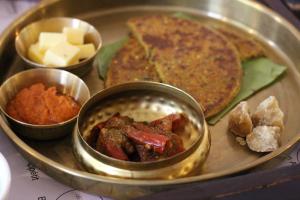 Le Meridien Jaipur Resort & Spa في جايبور: صينية طعام مع طبق من الطعام